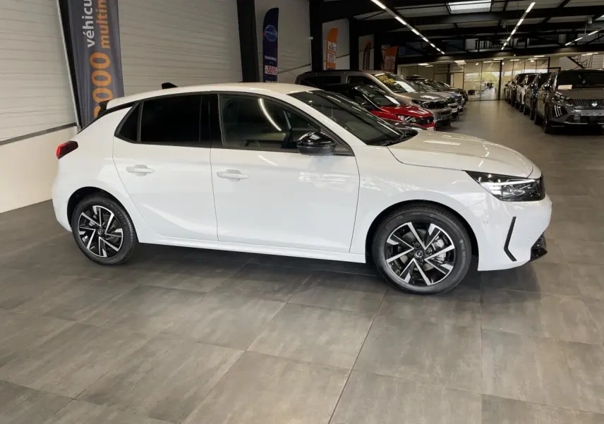 Opel Corsa blanche vue de profil côté gauche en intérieur, avec jantes alliage et vitres teintées.