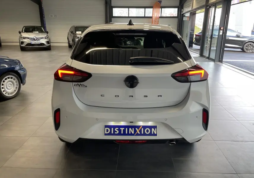 Vue arrière d'une Opel Corsa blanche 2026 avec feux LED allumés dans un showroom.