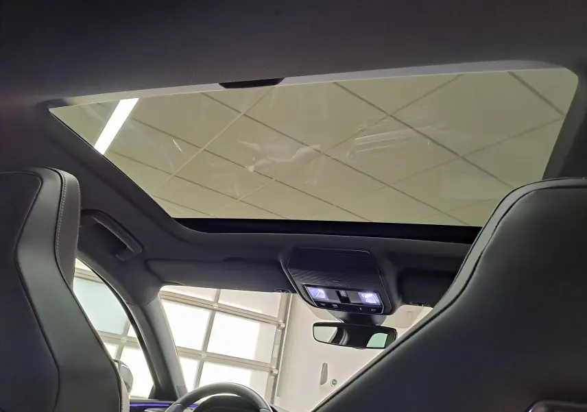 Vue intérieure du toit ouvrant panoramique de la CUPRA Leon 2024, avec sièges avant en cuir noir et ciel de toit gris.