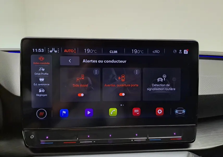Écran tactile central de la CUPRA Leon 2024 montrant les alertes au conducteur avec interface moderne et éclairage bleu.