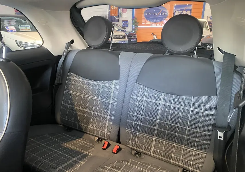 Vue intérieure arrière des sièges arrière en tissu à motif écossais gris et noir d'une FIAT 500 Lounge 2019.