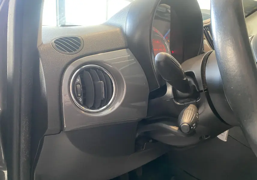 Détail intérieur côté gauche du tableau de bord gris foncé avec aérateur rond et commandes FIAT 500 Lounge 2019.