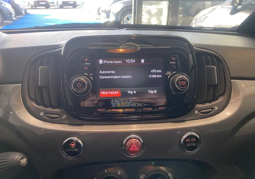 Tableau de bord de Fiat 500 gris foncé, vue frontale centrée sur l’écran multimédia avec commandes autour.