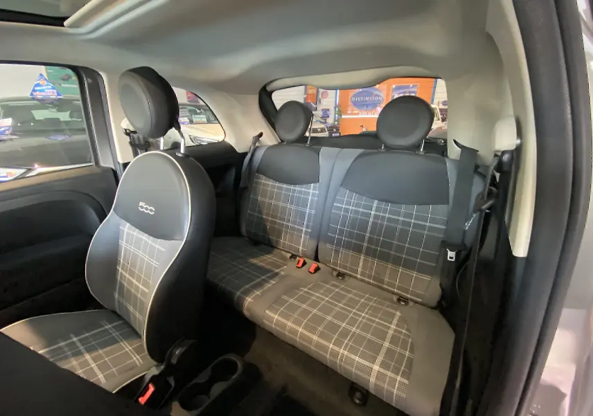 Vue intérieure côté droit de la FIAT 500 1.2 8V Lounge 2019 avec sièges en tissu à motif carreaux gris et noir.