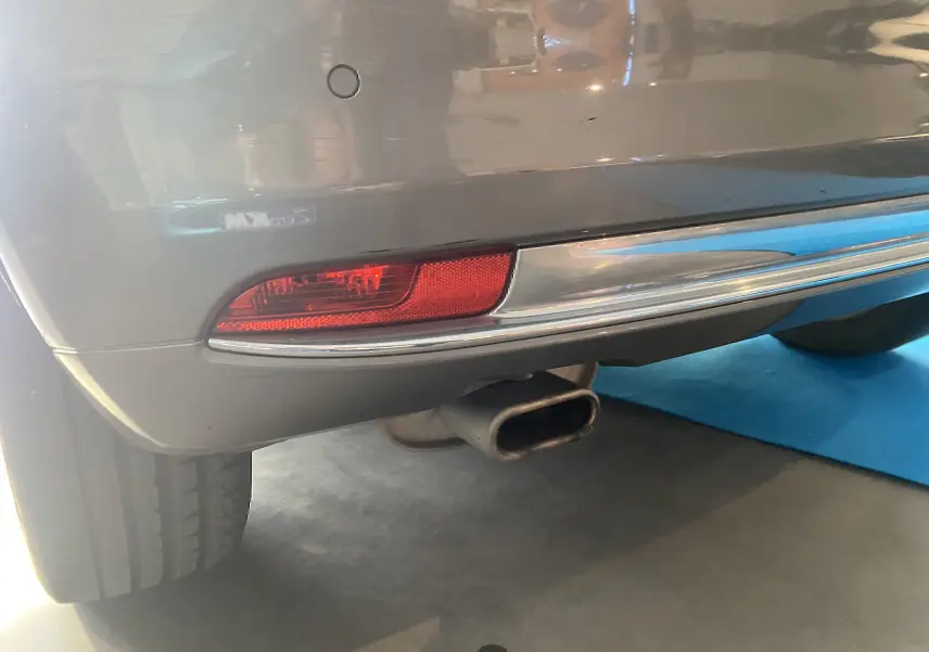 Gros plan sur le feu arrière droit et l’échappement d’une FIAT 500 gris foncé, vue arrière basse.