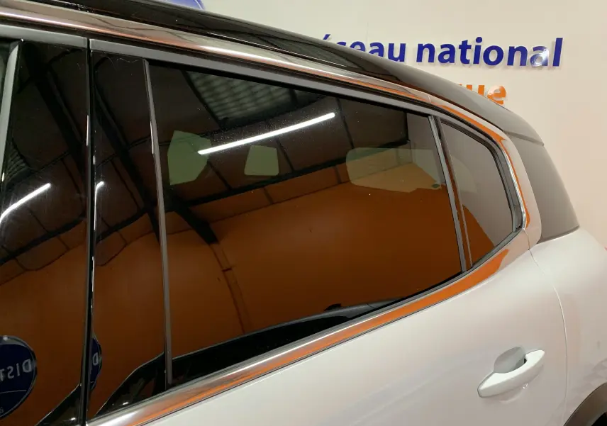 Vue latérale droite sur la porte arrière blanche du Citroën C5 Aircross Hybride 136 Max avec vitres teintées.
