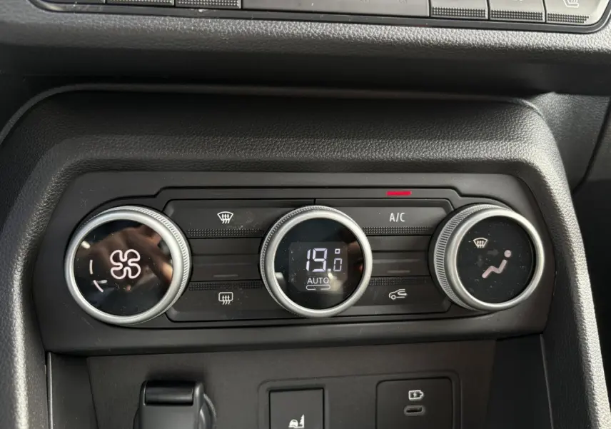 Gros plan sur les commandes de climatisation automatique du Dacia Jogger 2024, affichant 19°C et réglages ventilateur.