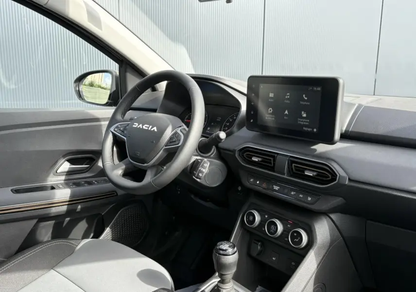 Intérieur du Dacia Jogger 2024, vue côté conducteur, volant multifonction et écran tactile 8 pouces au tableau de bord.