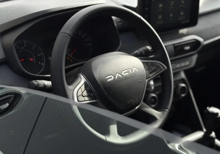 Volant DACIA JOGGER vu de près côté conducteur, tableau de bord et écran tactile en arrière-plan.