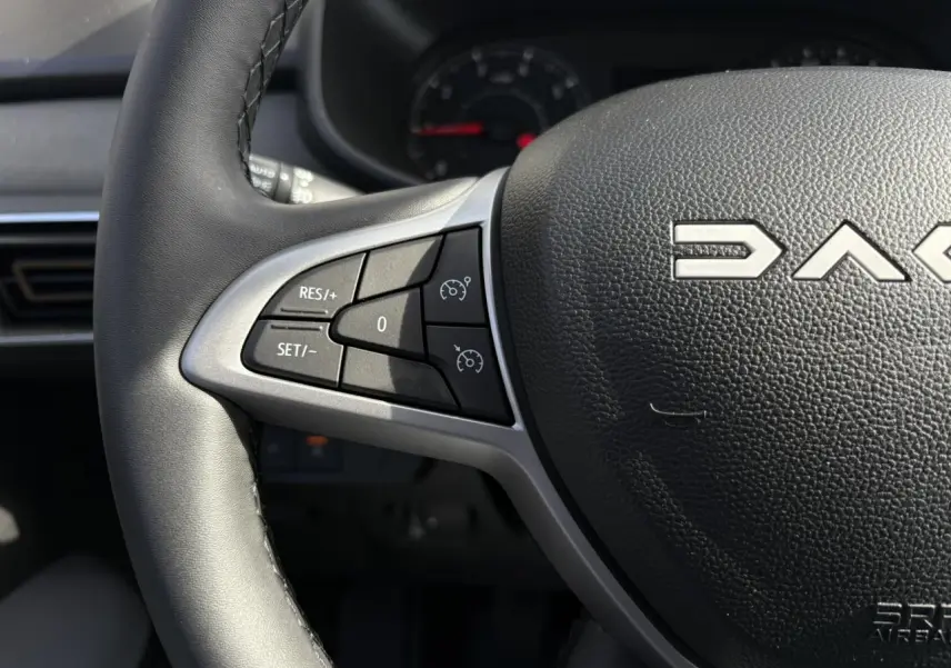 Gros plan sur le volant noir du Dacia Jogger 2024 avec commandes de régulateur de vitesse intégrées.
