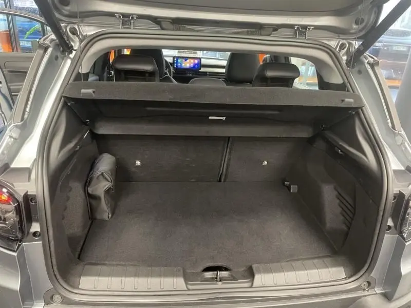 Coffre ouvert en vue arrière du Jeep Avenger 2025 gris, montrant l'espace de chargement et la tablette cache-bagages.