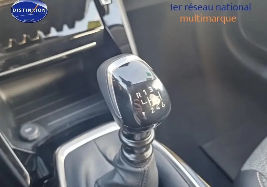 Gros plan sur le levier de vitesses manuel noir dans l'habitacle d'une Peugeot 208 gris artense.