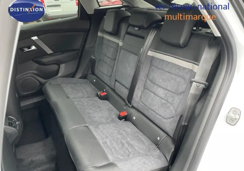 Vue intérieure côté arrière droit montrant les sièges arrière en cuir et tissu gris d'une Citroën C4 blanche 2024.
