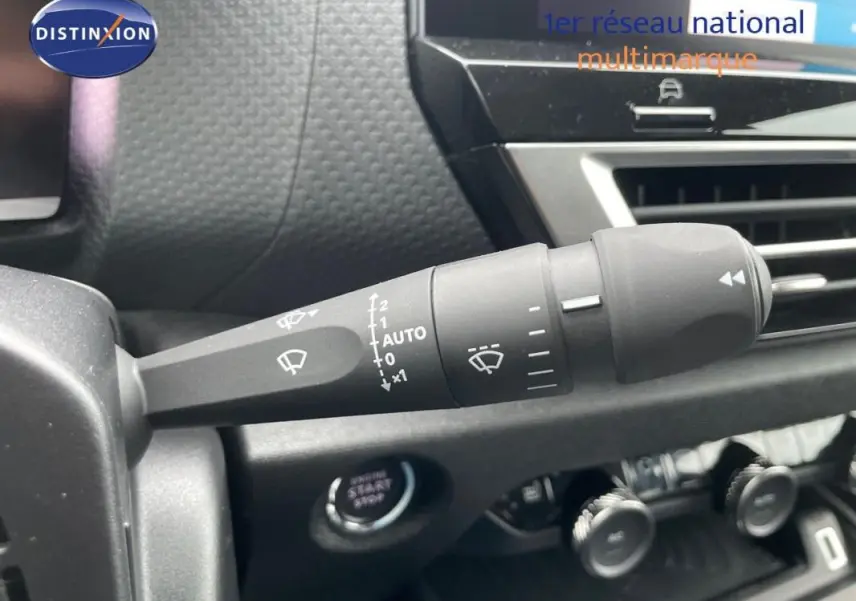 Gros plan sur la commande des essuie-glaces dans l’habitacle de la Citroën C4 blanche 2024, côté gauche du volant.