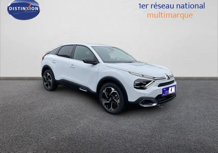 Citroën C4 blanc vue 3/4 avant droit, jantes aluminium noires et détails noirs contrastants sur carrosserie.