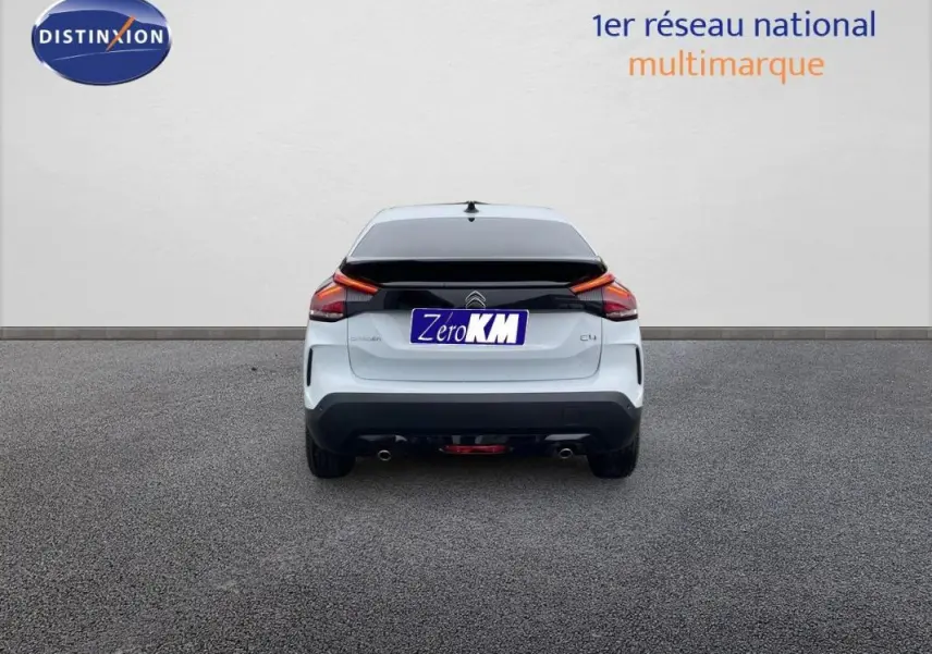 Vue arrière d'une Citroën C4 blanche 2024 avec feux arrière LED et double sortie d'échappement visible.