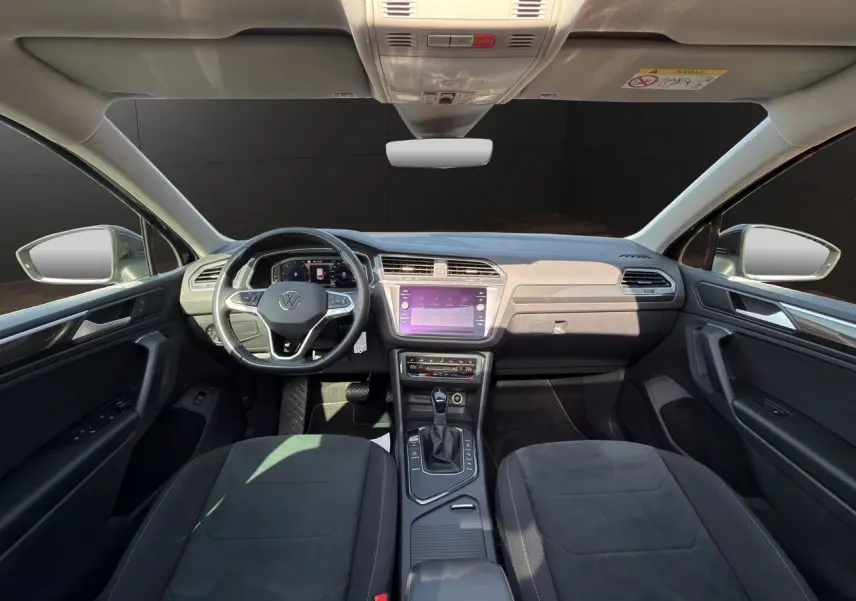 Vue intérieure avant du Volkswagen Tiguan 2.0 TDI noir intense, avec tableau de bord digital et écran tactile central.