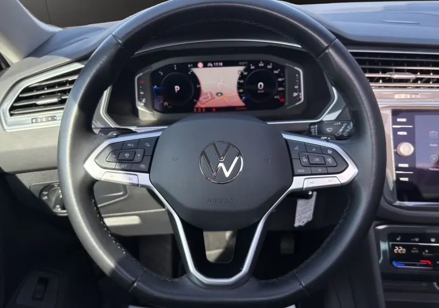 Vue rapprochée du volant cuir multifonction noir avec tableau de bord numérique et écran tactile du Volkswagen Tiguan 2022.