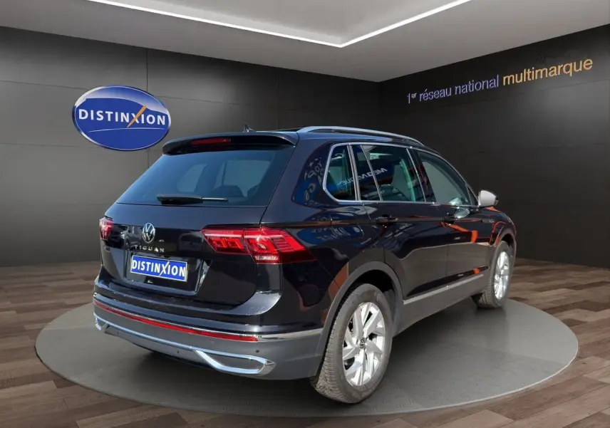 Volkswagen Tiguan noir intense 2022, vue 3/4 arrière droit, avec jantes alu 18 pouces et feux LED distinctifs.