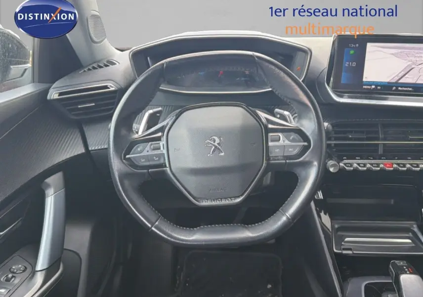 Vue intérieure centrée sur le volant noir du Peugeot 2008 avec tableau de bord numérique et écran tactile GPS.