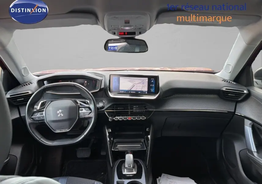 Vue intérieure avant du Peugeot 2008 rouge avec toit noir, montrant le tableau de bord et l'écran central tactile.