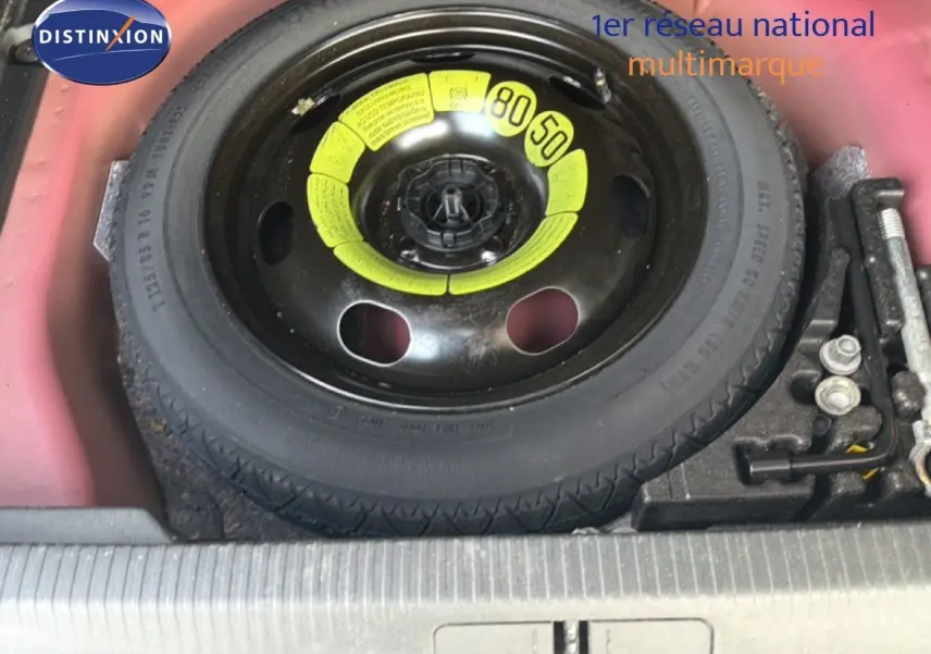 Vue rapprochée de la roue de secours noire avec marquages jaunes dans le coffre rouge du Peugeot 2008 2020 toit noir.