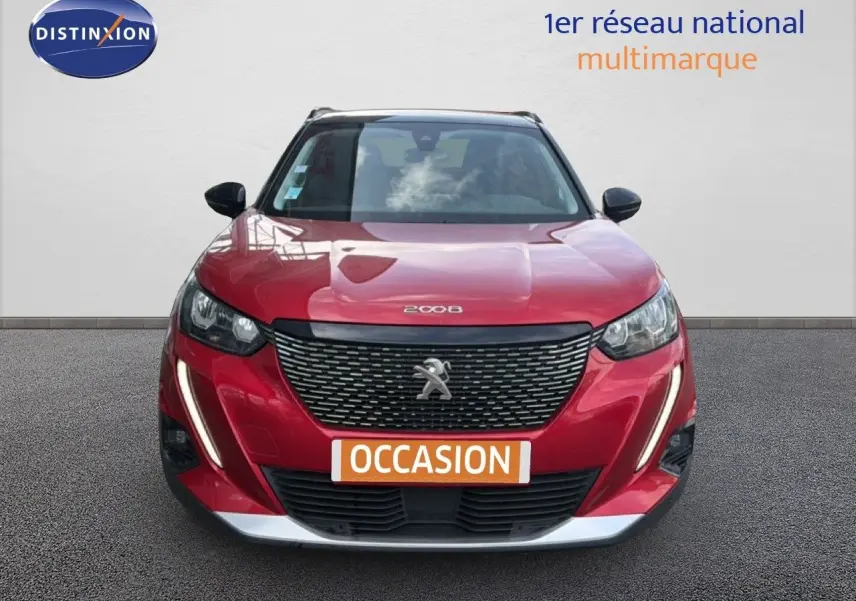 Vue avant d'un Peugeot 2008 rouge à toit noir avec calandre noire et feux LED en forme de griffes.