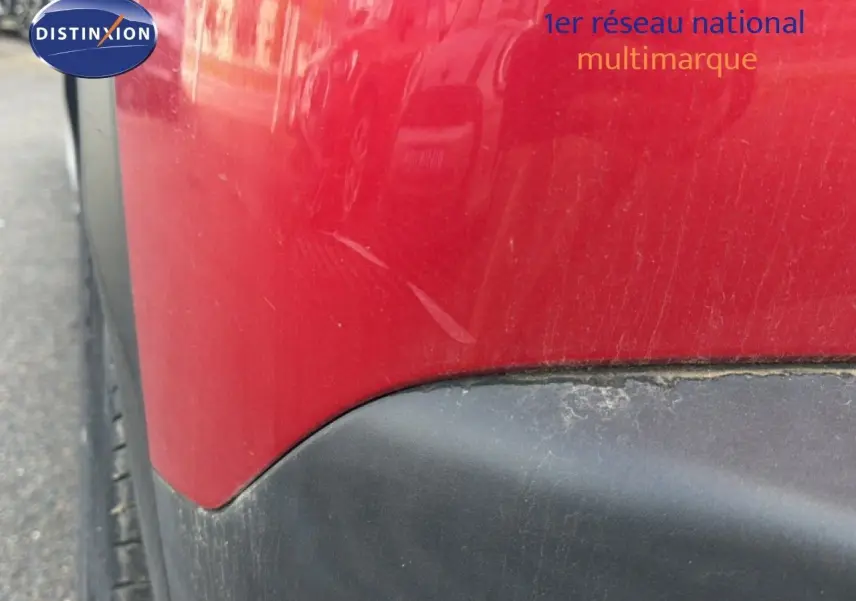 Gros plan sur l'aile arrière gauche rouge avec bas de caisse noir d'un Peugeot 2008 2020, version diesel.