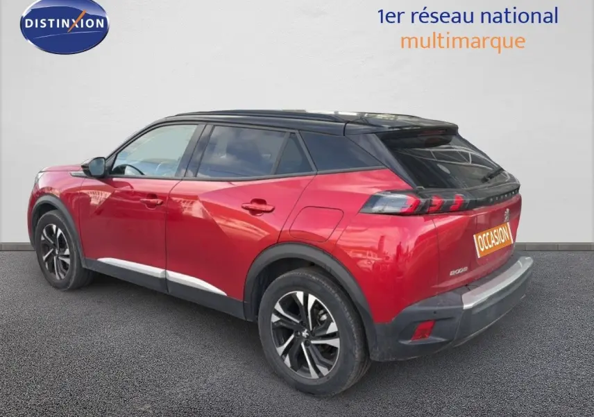 Peugeot 2008 rouge avec toit noir, vue 3/4 arrière droit, jantes alliage et feux arrière LED distinctifs.