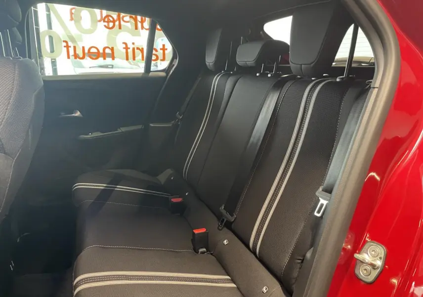 Vue intérieure côté droit sur la banquette arrière noire avec surpiqûres blanches d’une Opel Corsa rouge.