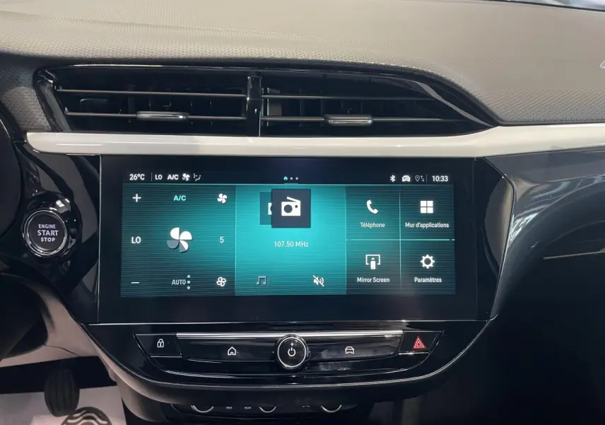 Écran tactile 10 pouces central de la console d’une Opel Corsa rouge, affichant la climatisation et les options multimédia.