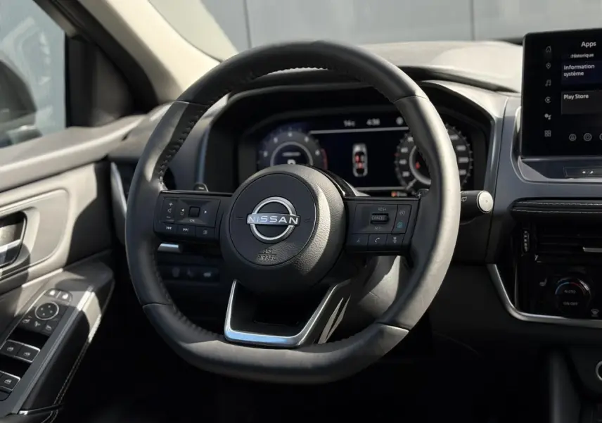 Volant cuir noir avec commandes intégrées dans l'habitacle du Nissan Qashqai III 2025, tableau de bord numérique visible