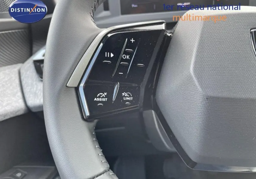 Gros plan sur les commandes au volant cuir du Peugeot 3008 bleu 2025, avec boutons d'assistance et limitation.