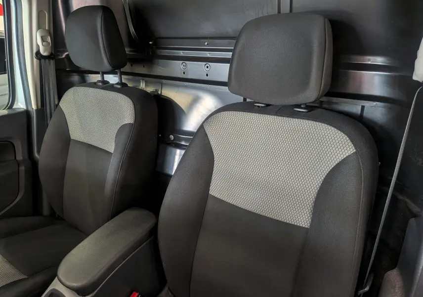 Vue rapprochée des sièges avant en tissu gris et noir du Renault Kangoo Express Grand Volume 2021, intérieur utilitaire.