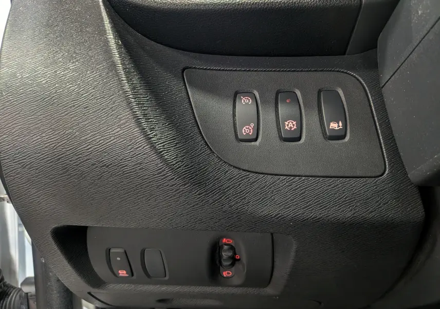 Gros plan sur les commandes de réglages et assistances du tableau de bord du Renault Kangoo Express blanc, version 2021.