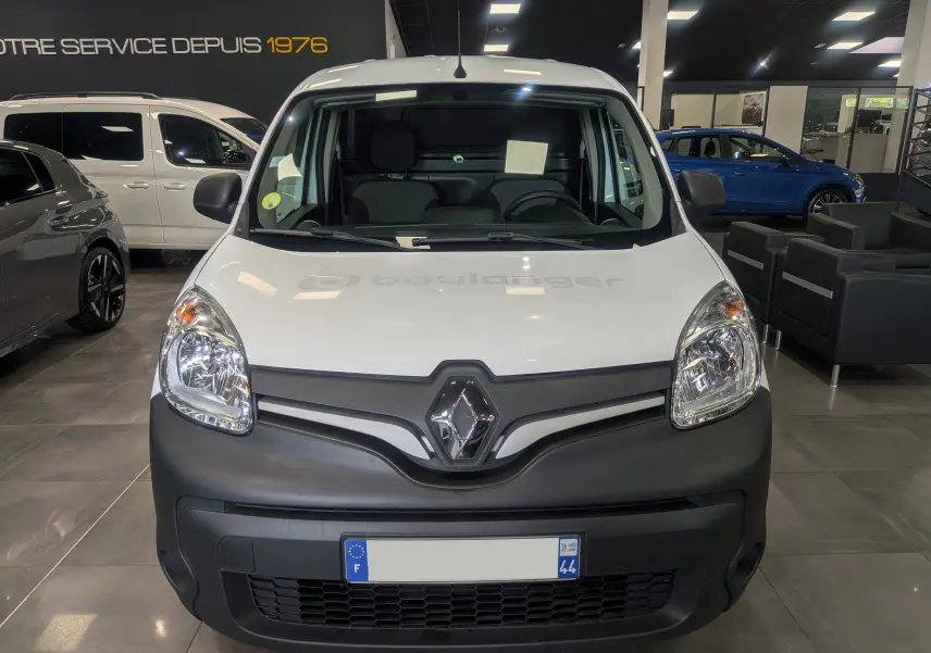 Vue avant d’un Renault Kangoo Express blanc minéral avec pare-chocs noir mat dans un showroom.