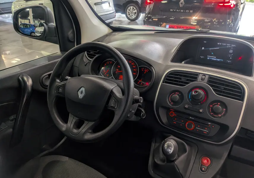 Vue intérieure côté conducteur du Renault Kangoo Express 2021 avec tableau de bord, volant, levier de vitesses et écran de navigation.