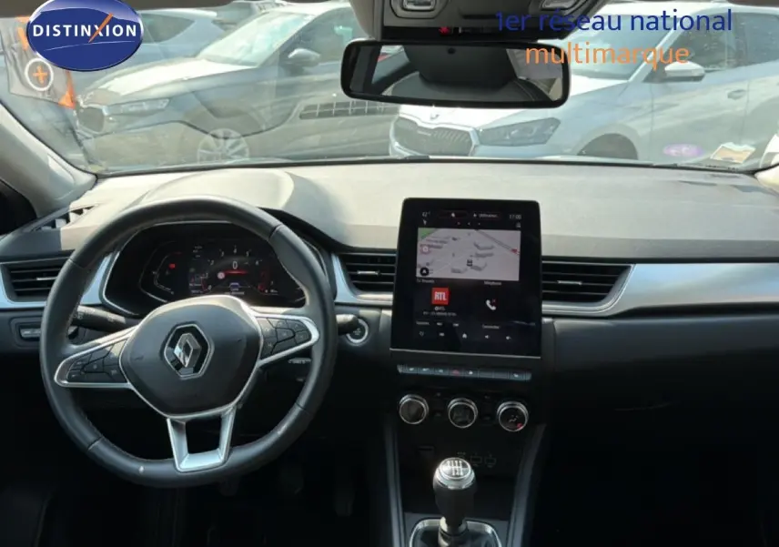 Vue intérieure du tableau de bord du Renault Captur bleu marine fumé 2022, avec volant multifonction et écran tactile central.