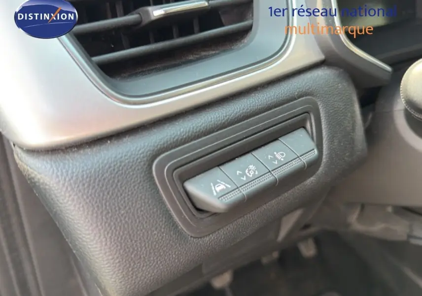 Détail des commandes d'assistance au conducteur sur le tableau de bord du Renault Captur bleu marine fumé 2022.