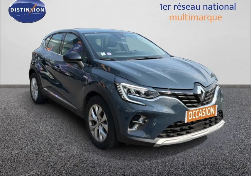 Renault Captur bleu marine fumé en 3/4 avant droit, SUV compact avec feux LED et calandre distinctive.