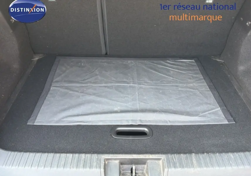 Coffre ouvert d’un Renault Captur 2022 bleu marine fumé, vue intérieure montrant le tapis de sol et le revêtement noir.