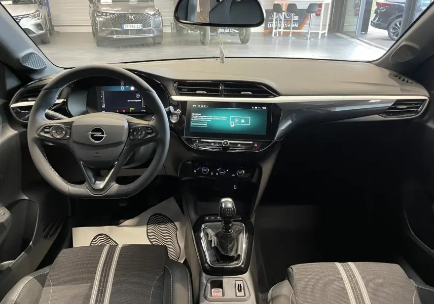 Vue intérieure avant de l’Opel Corsa gris, montrant le volant, écran tactile 10 pouces et levier de vitesses manuel.
