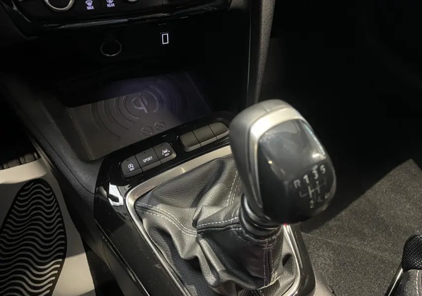 Gros plan sur la console centrale de l’Opel Corsa gris, mettant en valeur le levier de vitesses manuel et les boutons de contrôle.
