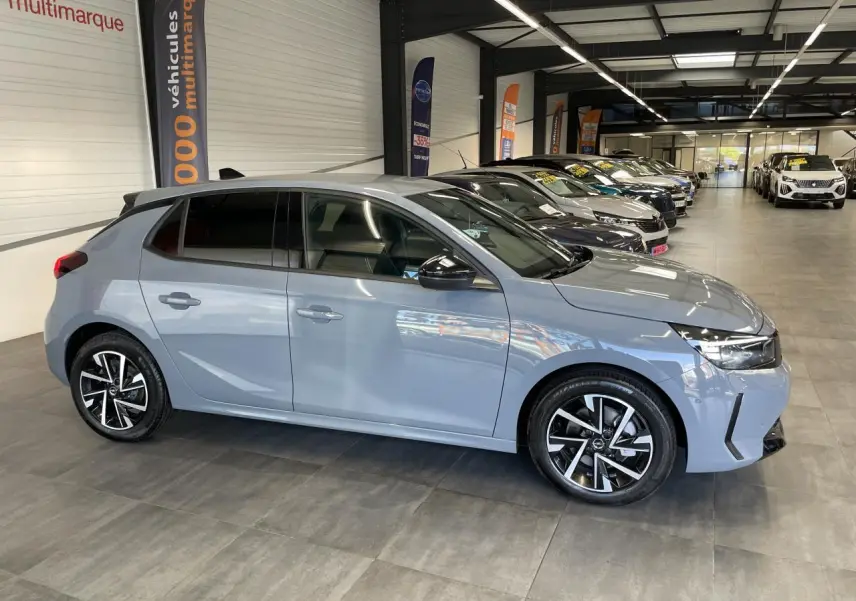 Opel Corsa gris clair vue de profil côté gauche, avec jantes alliage et vitres arrière surteintées.