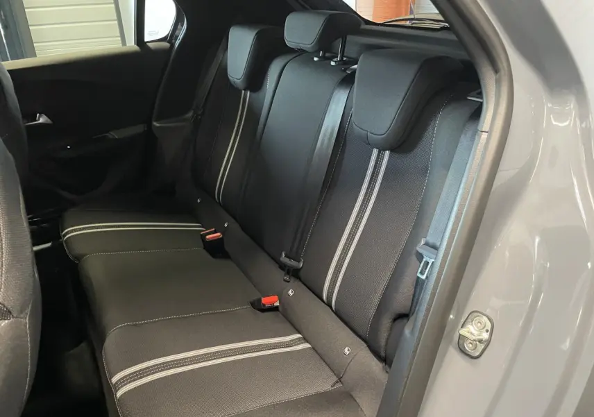 Vue intérieure côté droit sur la banquette arrière noire avec surpiqûres blanches de l’Opel Corsa gris 2026.