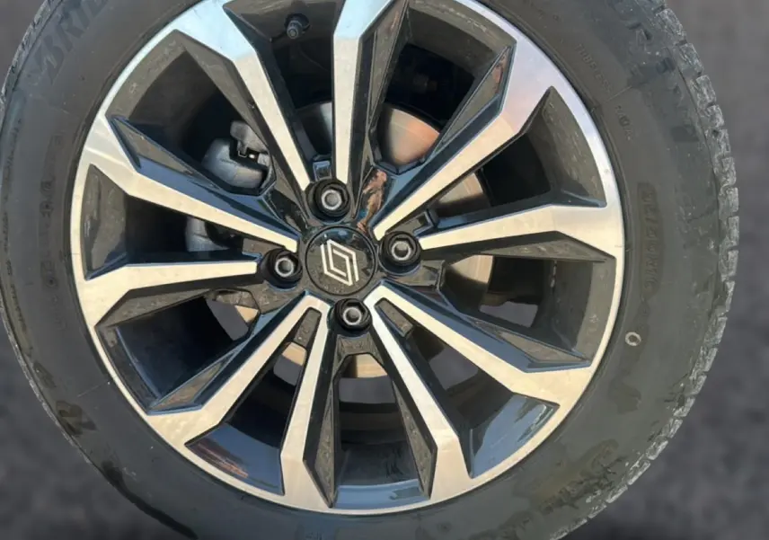 Gros plan sur une jante alliage bicolore noir et argent avec logo Renault au centre, montée sur pneu Bridgestone.