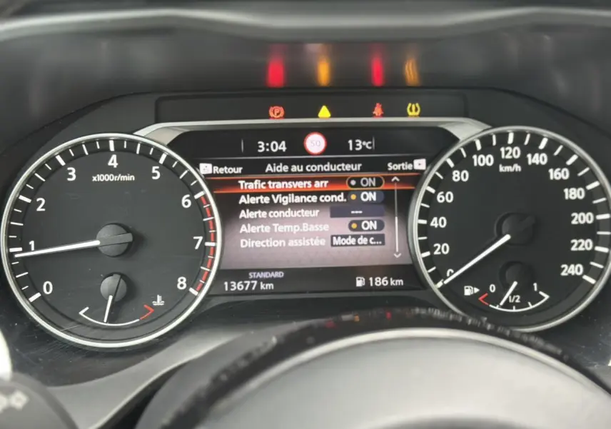 Tableau de bord du Nissan Qashqai 2024 montrant l'écran d'aide au conducteur et les compteurs de vitesse et régime moteur.