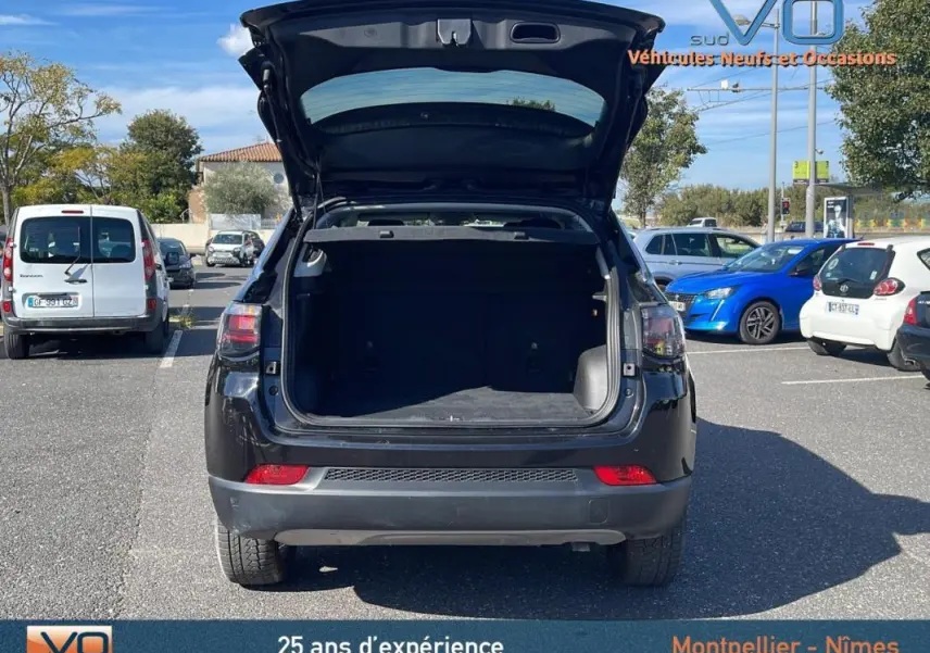 Vue arrière du Jeep Compass noir 2023 avec coffre ouvert, montrant l'espace de chargement vide en extérieur.