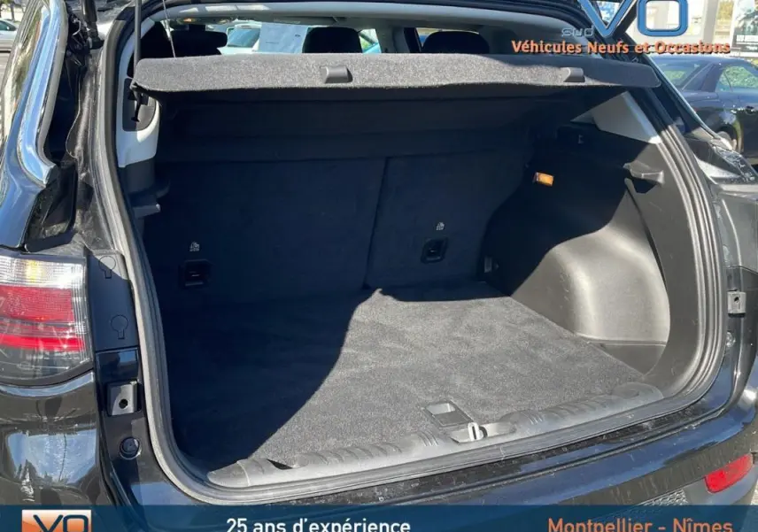 Coffre ouvert vu de l'arrière d'un Jeep Compass noir 2023, montrant l'espace de chargement propre et spacieux.