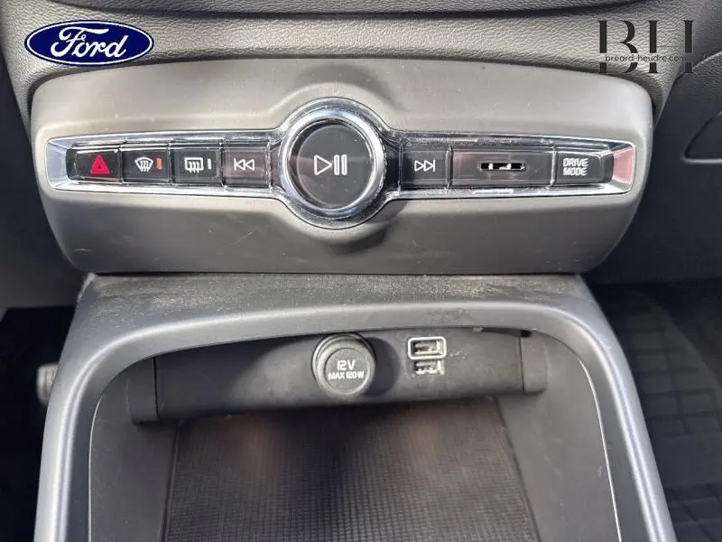 Vue rapprochée du panneau de commandes et prises USB d'un Volvo XC40 bleu Denim hybride rechargeable de 2021.